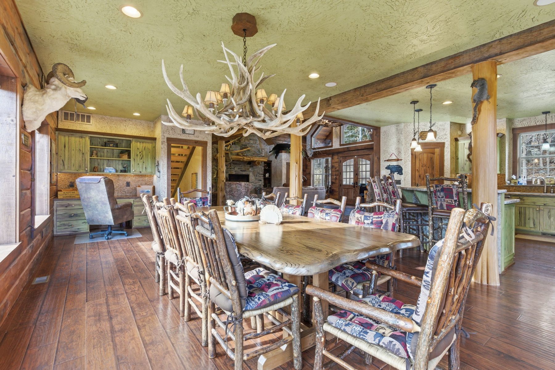 Dining table beneath an antler chandelier