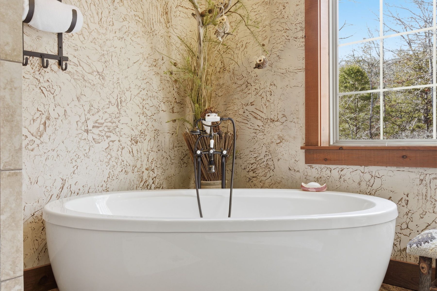 Freestanding soaking tub beneath a window
